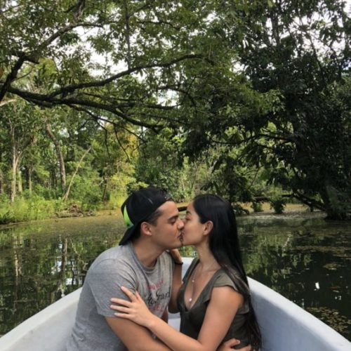 Man and woman kissing while sitting in boat